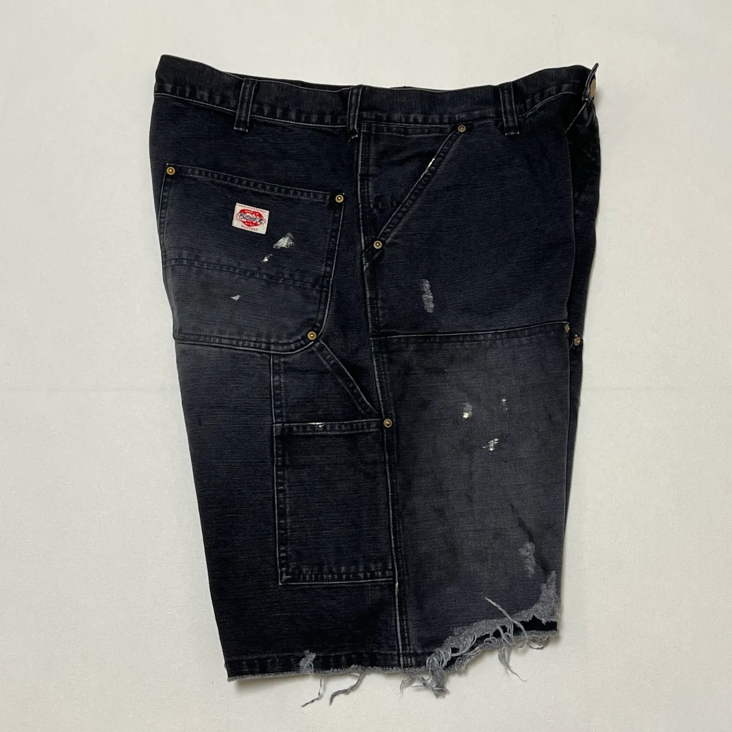 SAINT Mxxxxxx DOUBLE KNEE SHORTS/BLK Knee patches splashed with ink, washed and damaged denim shorts. Washed black S-XL. Custom woven and dyed denim denim with clear texture. Rewashed and faded to create local mottled fading/hole effects. Artificial distressing to simulate natural traces of wear. Original consistent damage treatment. Hand splashed ink and paint. Original consistent wash mark/pocket mark. Double knee patch. Rivet reinforcement. Improve functionality and enhance design.